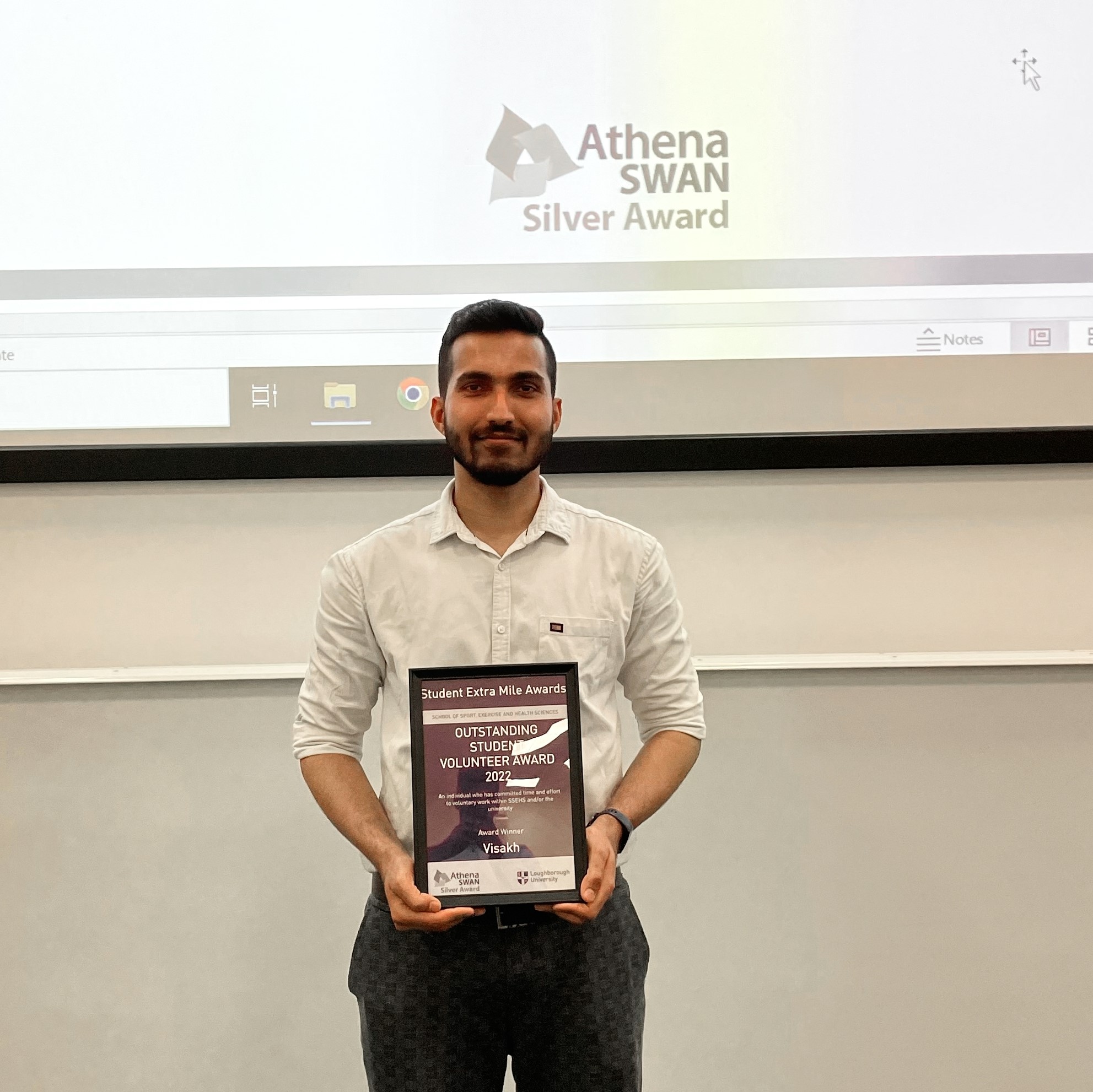 Visakh holding an Athena Swan award for Student Volunteer 2022